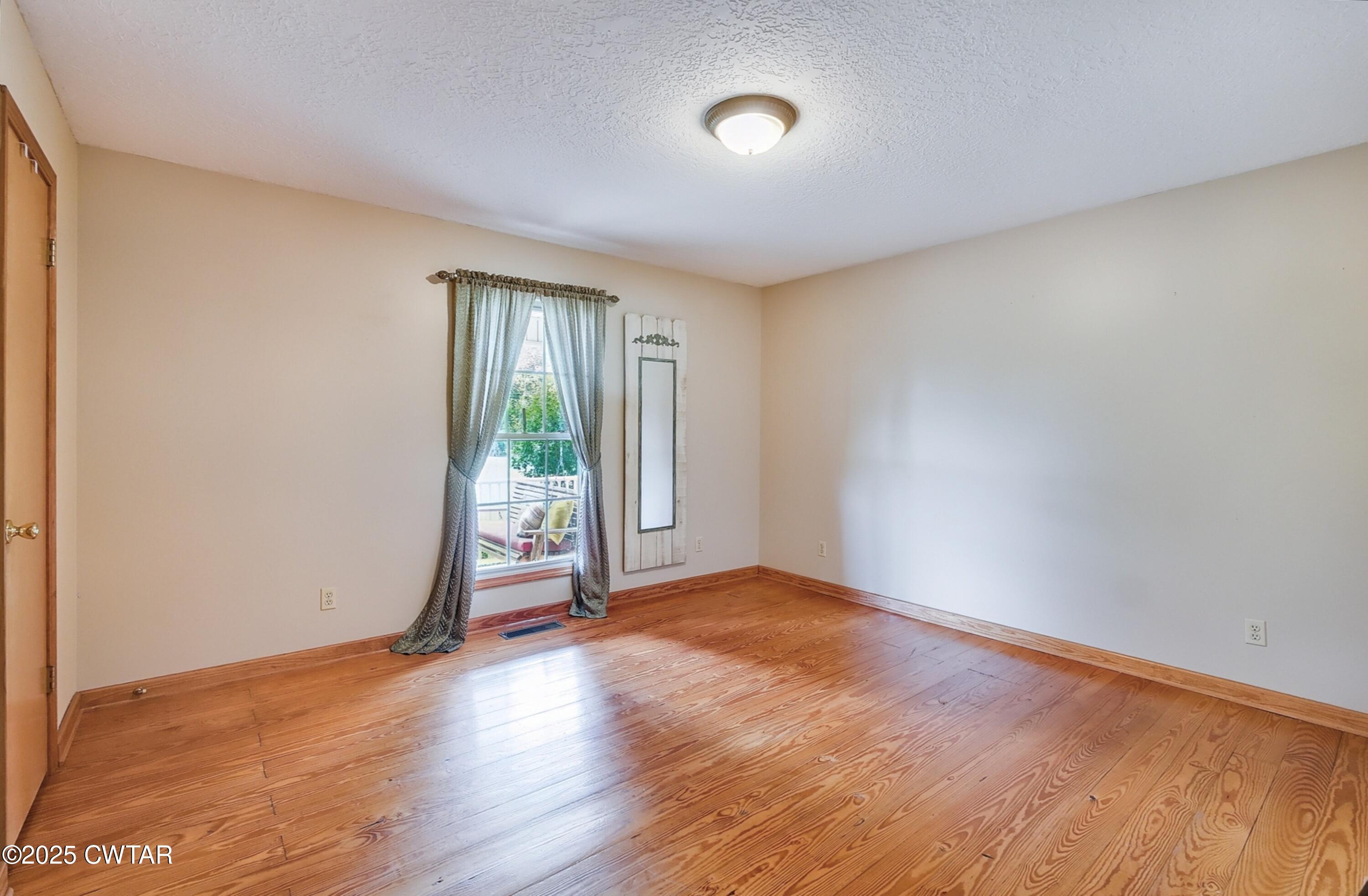 95 Stavely Road Medina, TN 38355 - Photo 18 of 33 an empty room with wooden floor and windows