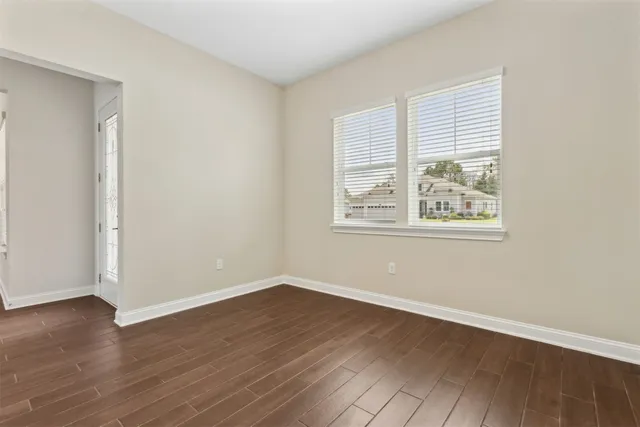 a kitchen with a sink dishwasher and white cabinets with wooden floor