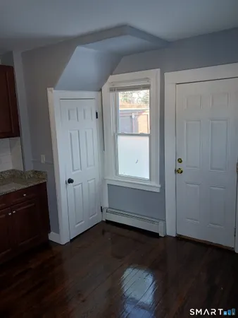 an empty room with wooden floor and cabinet