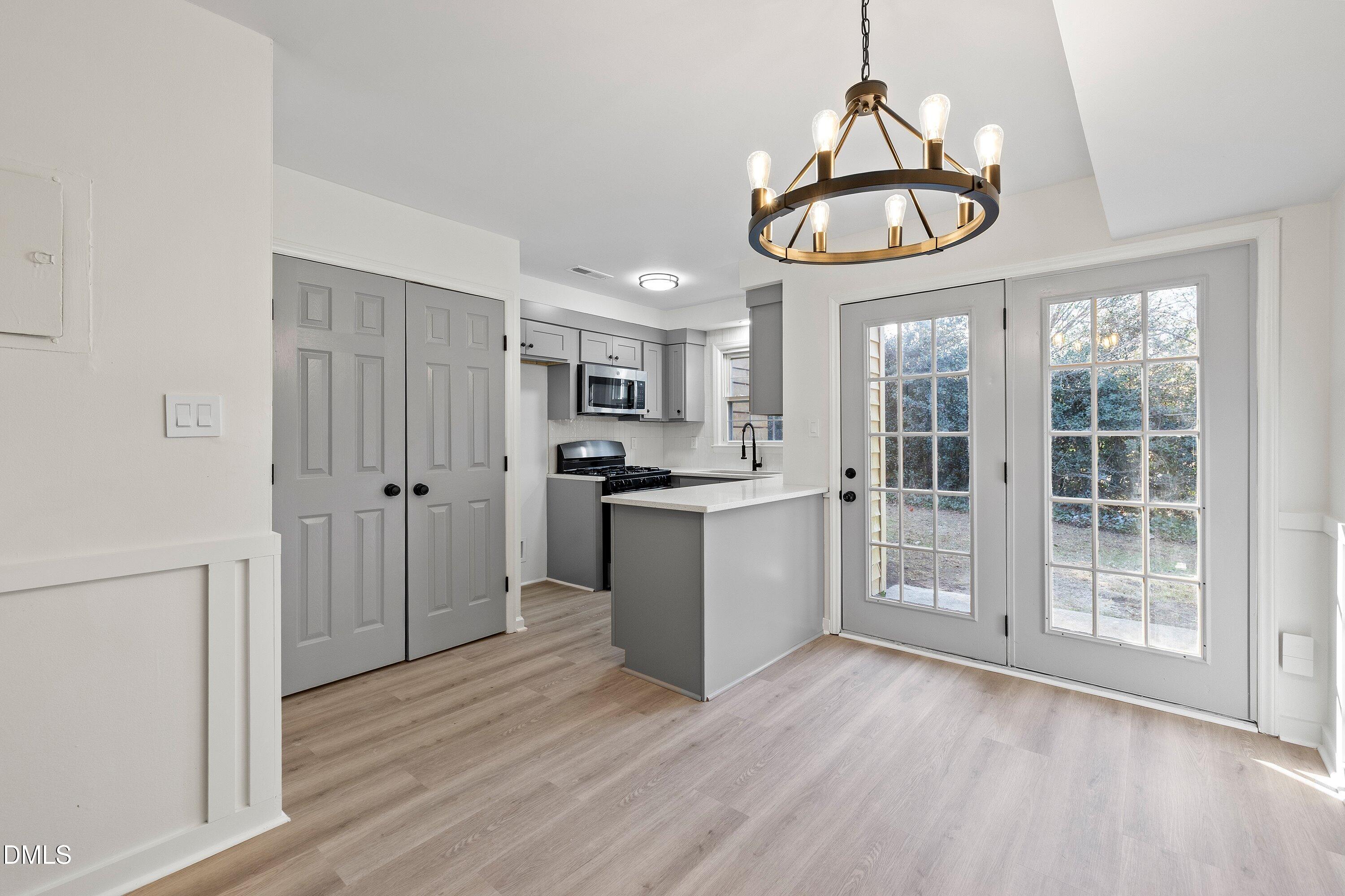 4705 Blue Bird Court, Unit E Raleigh, NC 27606 - Photo 12 of 32 a view of a kitchen with wooden floor and windows
