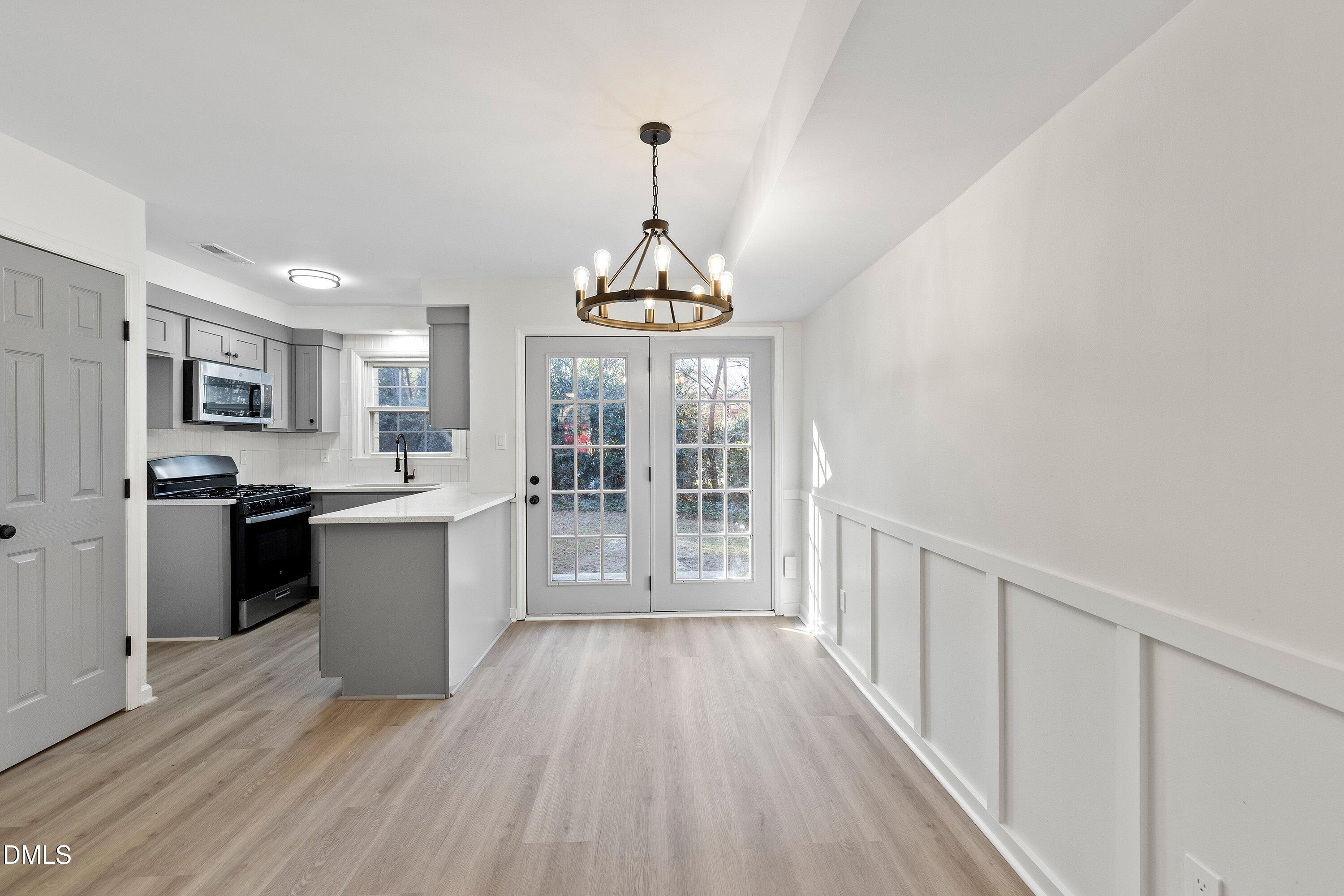 4705 Blue Bird Court, Unit E Raleigh, NC 27606 - Photo 13 of 32 a kitchen with wooden floors and refrigerator