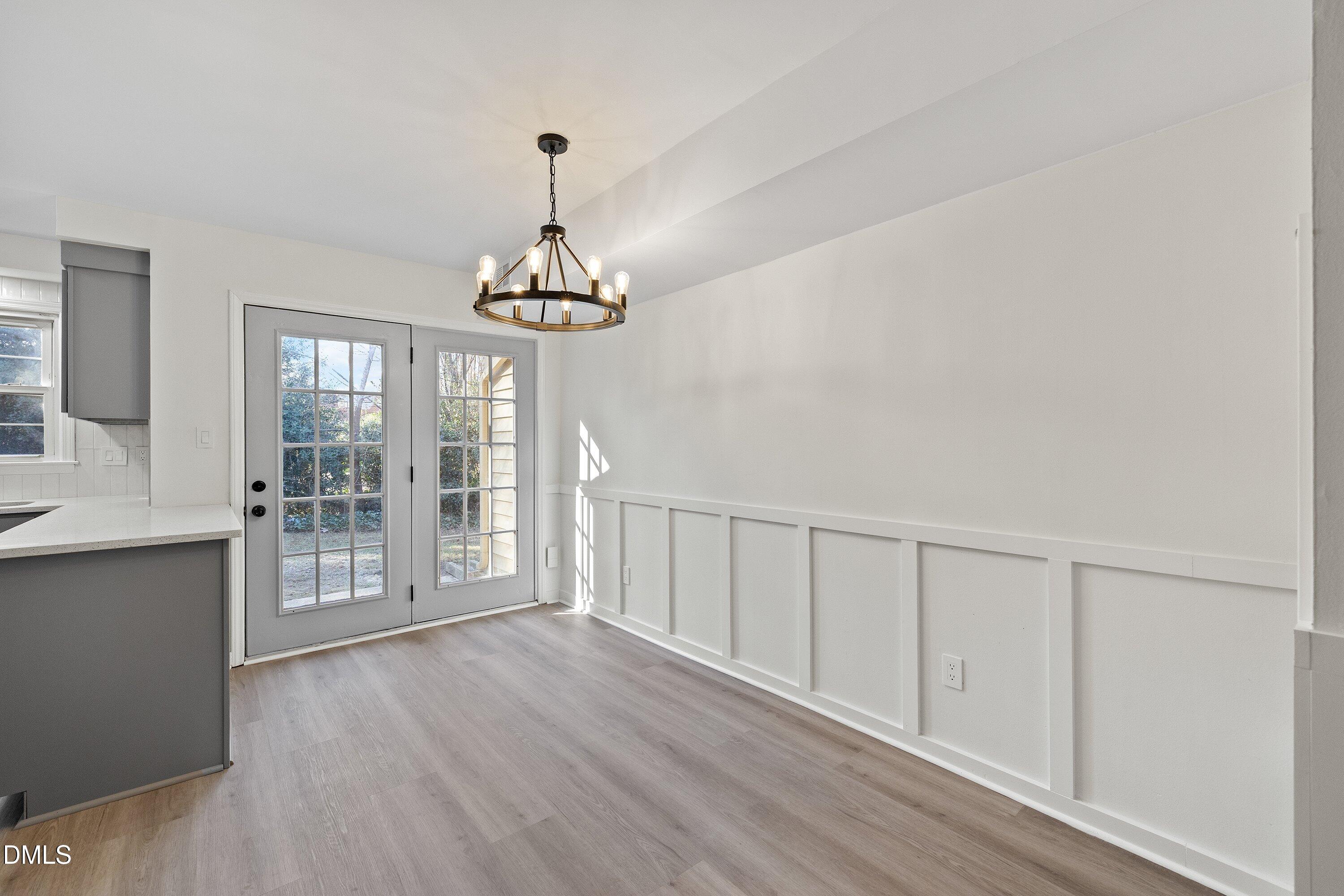 4705 Blue Bird Court, Unit E Raleigh, NC 27606 - Photo 18 of 32 a view of an empty room with wooden floor and a window