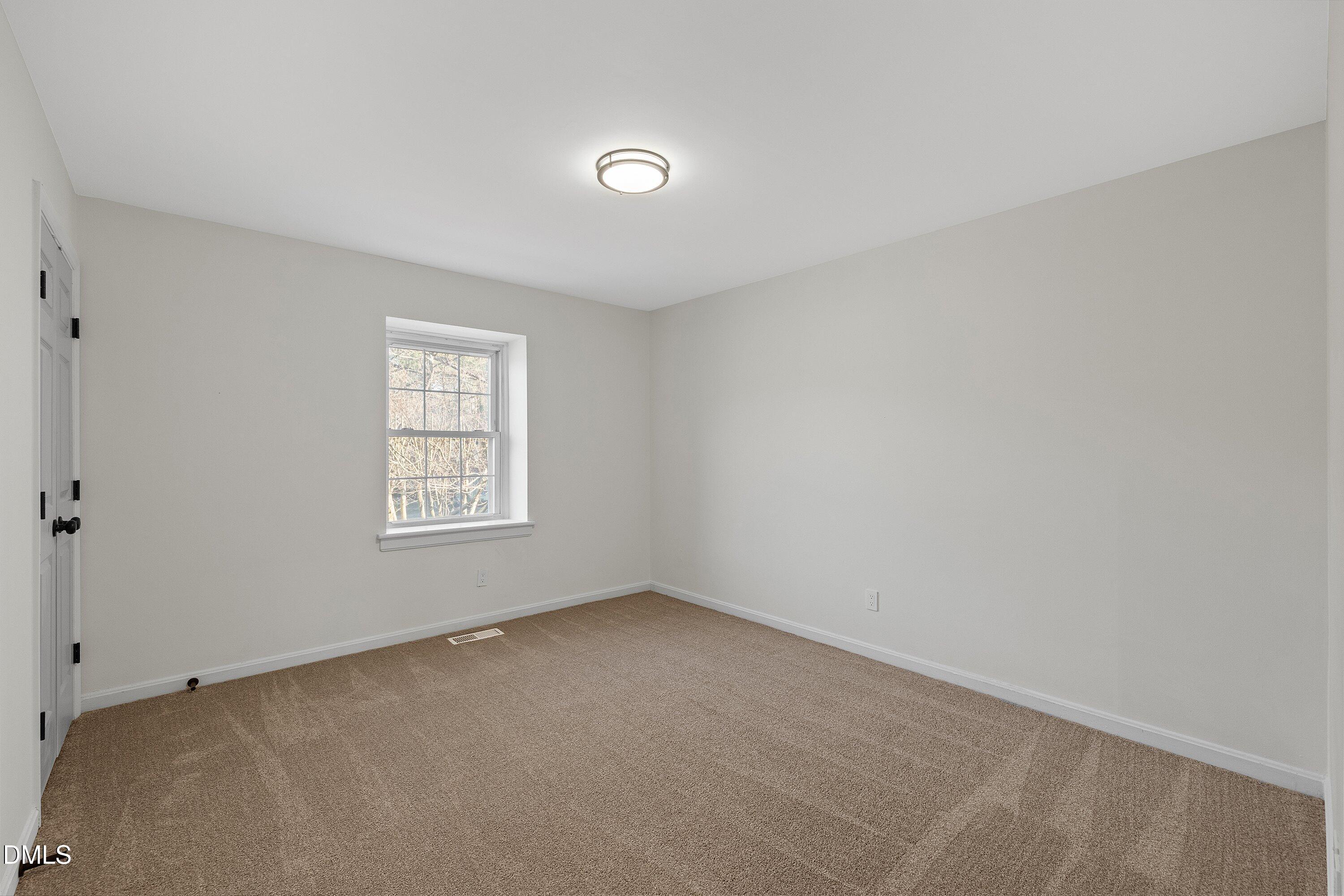 4705 Blue Bird Court, Unit E Raleigh, NC 27606 - Photo 22 of 32 an empty room with a window