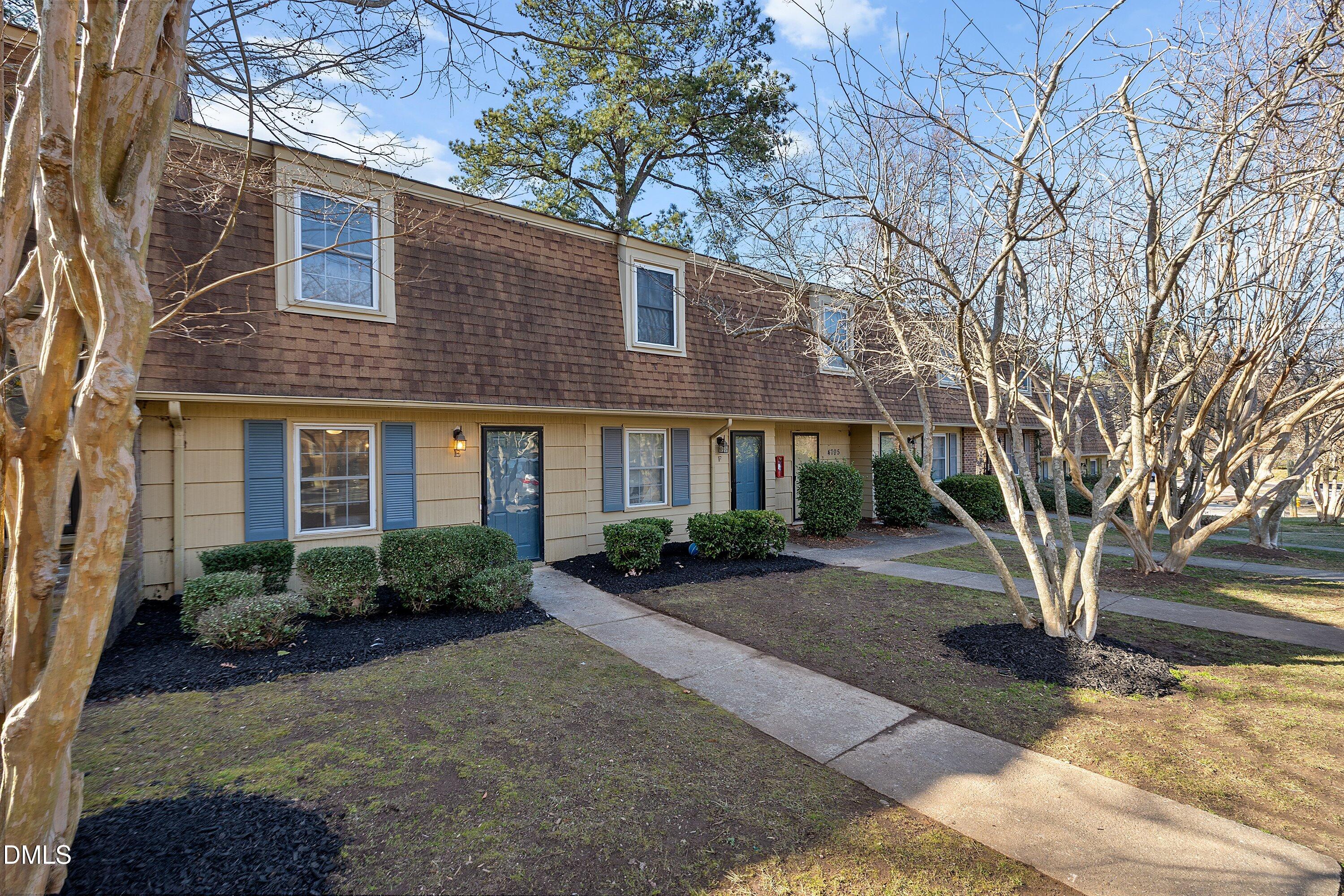 4705 Blue Bird Court, Unit E Raleigh, NC 27606 - Photo 26 of 32 a front view of a house with yard and parking