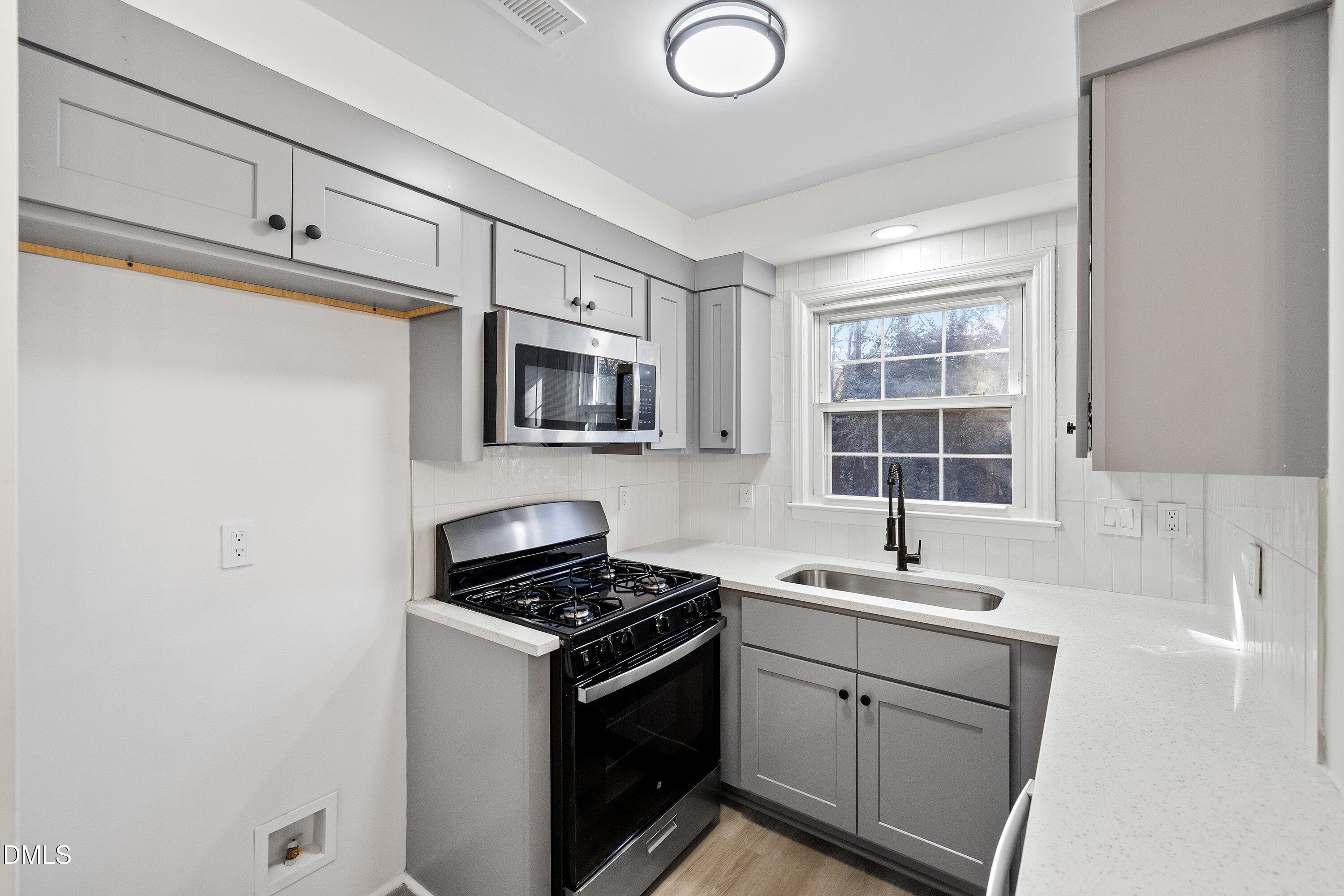 4705 Blue Bird Court, Unit E Raleigh, NC 27606 - Photo 10 of 32 a kitchen with a sink stove and microwave