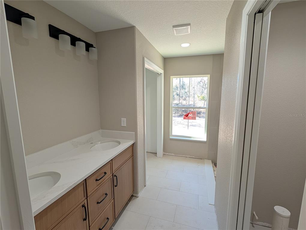 12769 Southwest 89th Street Dunnellon, FL 34432 - Photo 11 of 13 a bathroom with a granite countertop sink a toilet and a bathtub