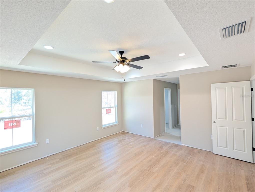 12769 Southwest 89th Street Dunnellon, FL 34432 - Photo 6 of 13 an empty room with wooden floor fan and windows