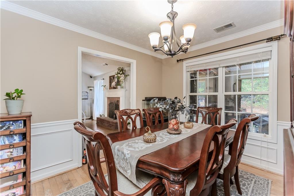 2790 Alcovy River View Dacula, GA 30019 - Photo 11 of 25 a view of a dining room with furniture a chandelier and wooden floor