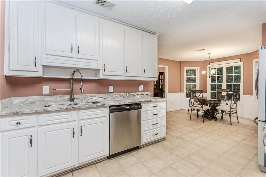 2790 Alcovy River View Dacula, GA 30019 - Photo 4 of 25 a kitchen with granite countertop white cabinets and white appliances