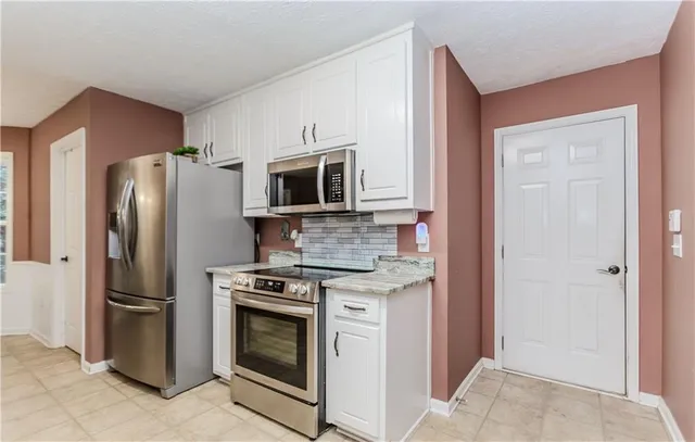 a kitchen with stainless steel appliances granite countertop a refrigerator stove and microwave