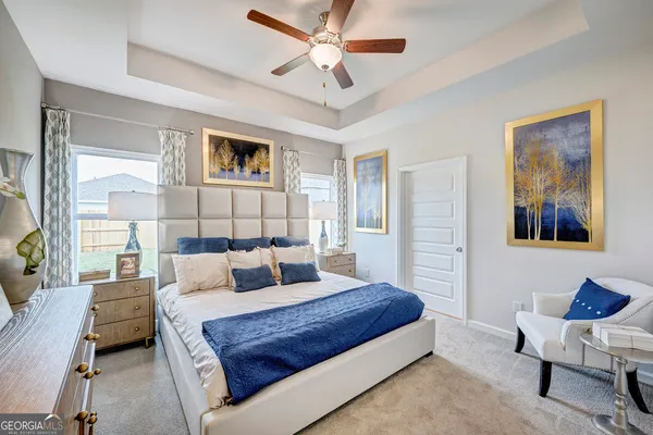 a bedroom with a large bed and a chandelier