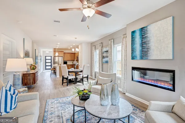 a living room with furniture and a dining table with kitchen view