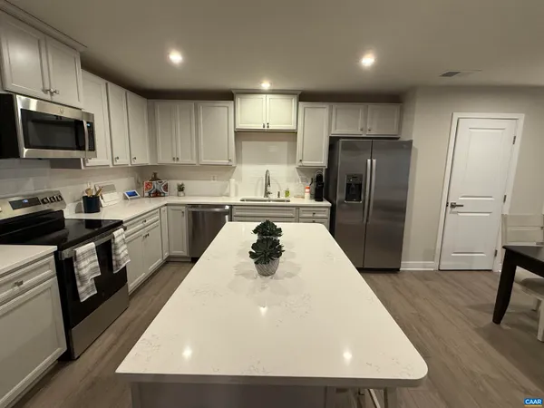 a kitchen with stainless steel appliances a refrigerator stove microwave and sink