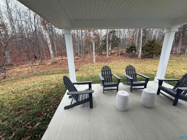 a view of a patio with table and chairs and floor to ceiling window