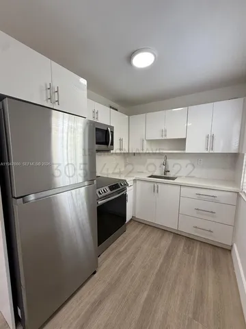 a kitchen with refrigerator a microwave and cabinets