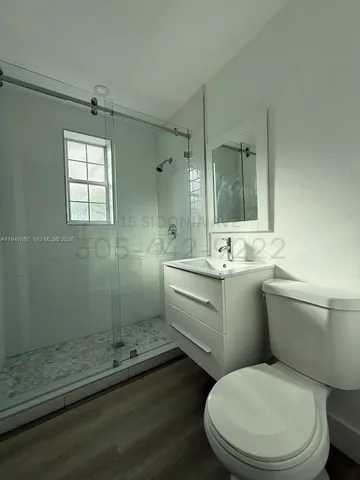 a bathroom with a granite countertop toilet a sink and a mirror
