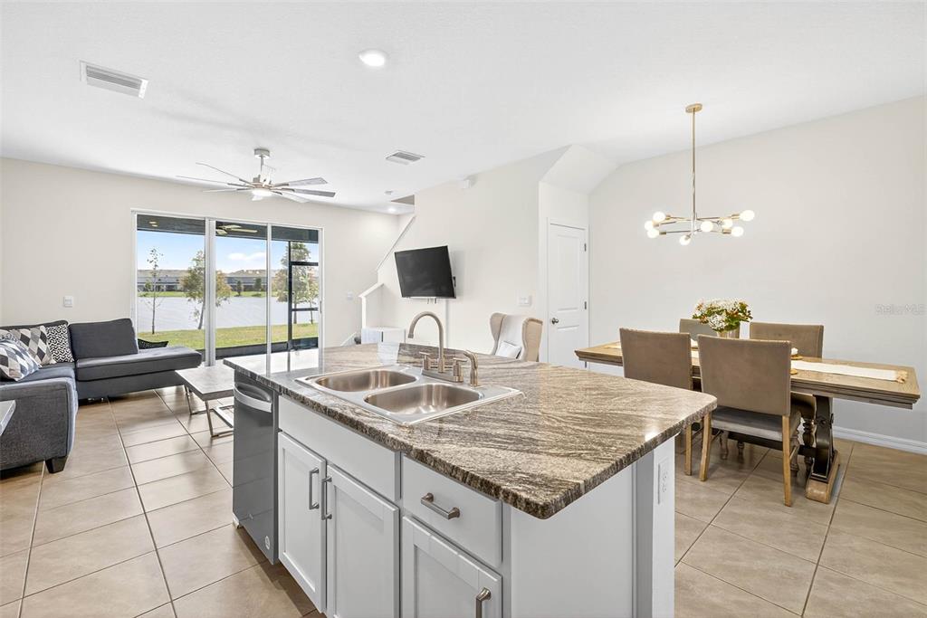 193 Mangrove Shade Circle Apollo Beach, FL 33572 - Photo 12 of 47 a kitchen with granite countertop kitchen island stainless steel appliances a sink stove and living room view
