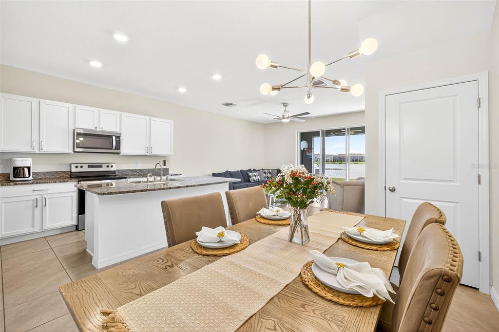193 Mangrove Shade Circle Apollo Beach, FL 33572 - Photo 10 of 47 a kitchen with stainless steel appliances kitchen island granite countertop a dining table chairs and view living room