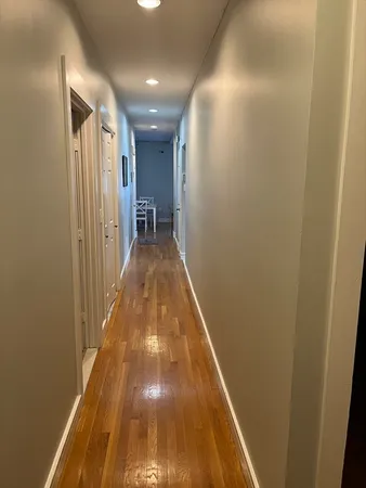 a view of a hallway with wooden floor