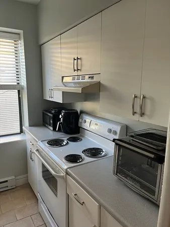 a white stove top oven sitting inside of a kitchen