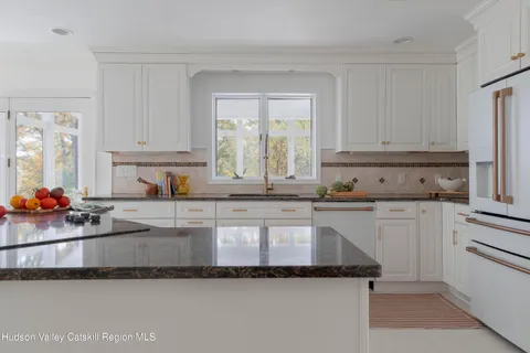 a kitchen with granite countertop a sink stainless steel appliances and cabinets