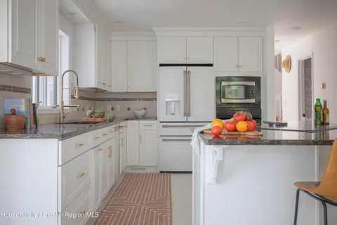 a kitchen with stainless steel appliances granite countertop a sink stove refrigerator and cabinets