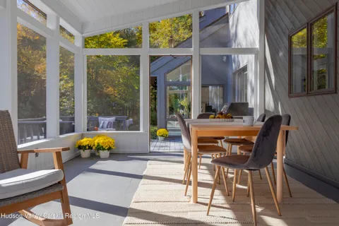 a dining room with furniture and large windows