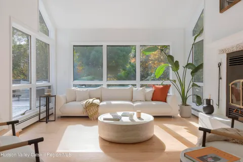a living room with fireplace furniture and a large window