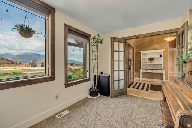 3054 West Ridgeline Road Stockton, UT 84071 - Photo 28 of 88 Living area featuring a mountain view, light colored carpet, and french doors