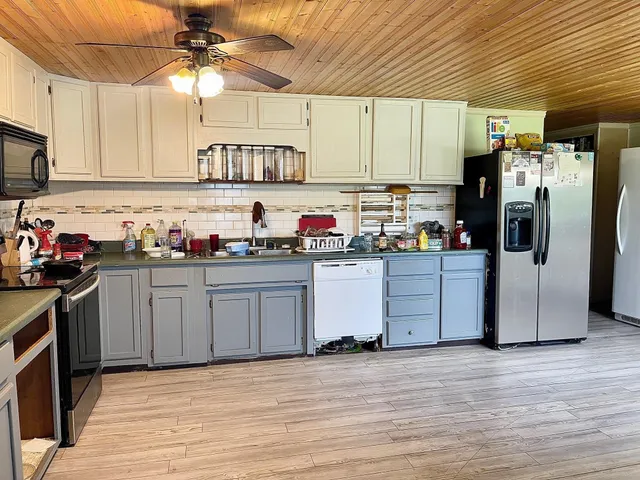 a kitchen with stainless steel appliances a refrigerator a sink a stove and cabinets