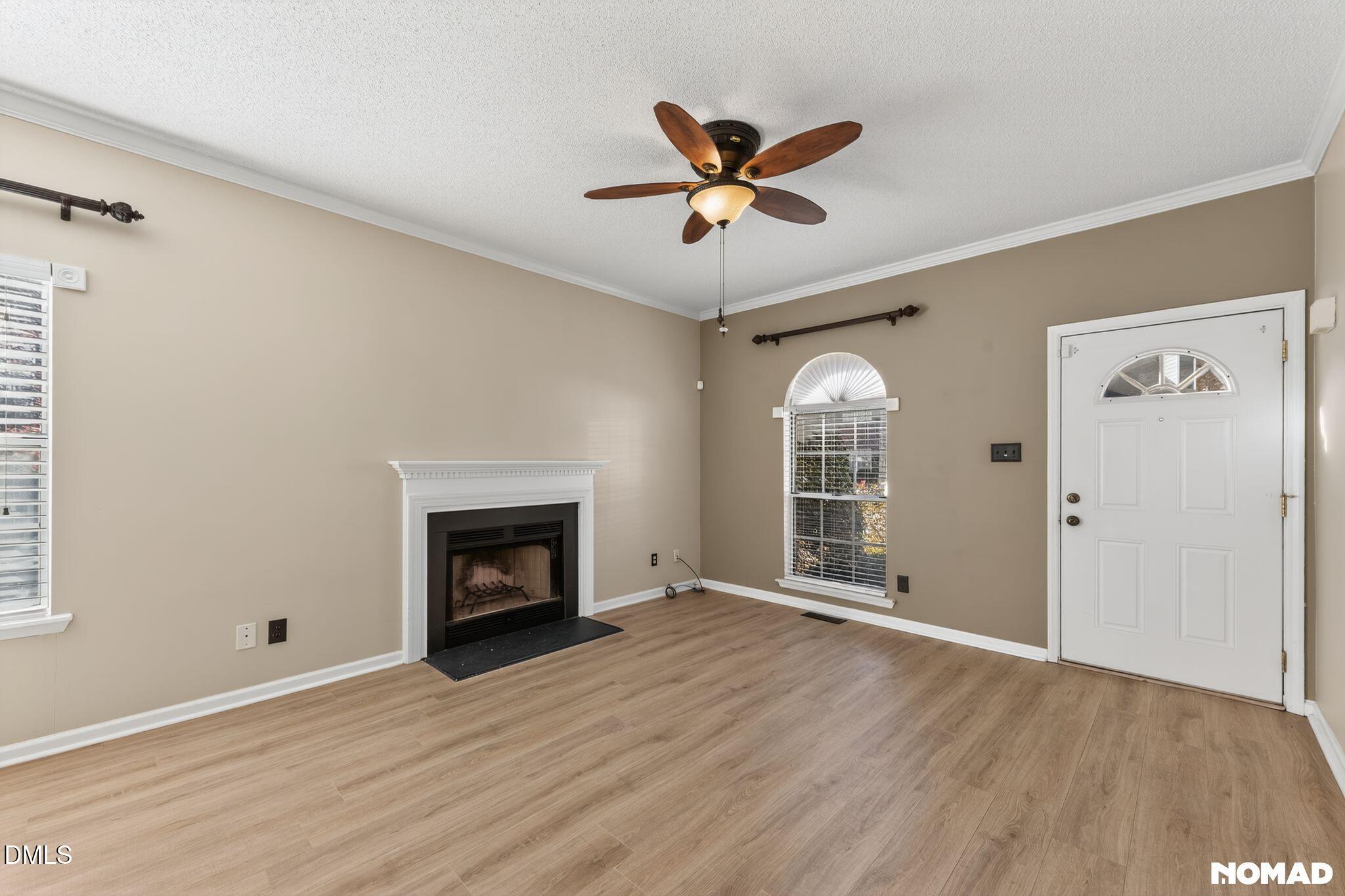 4456 Still Pines Drive Raleigh, NC 27613 - Photo 2 of 16 a view of an empty room with wooden floor fireplace and a window