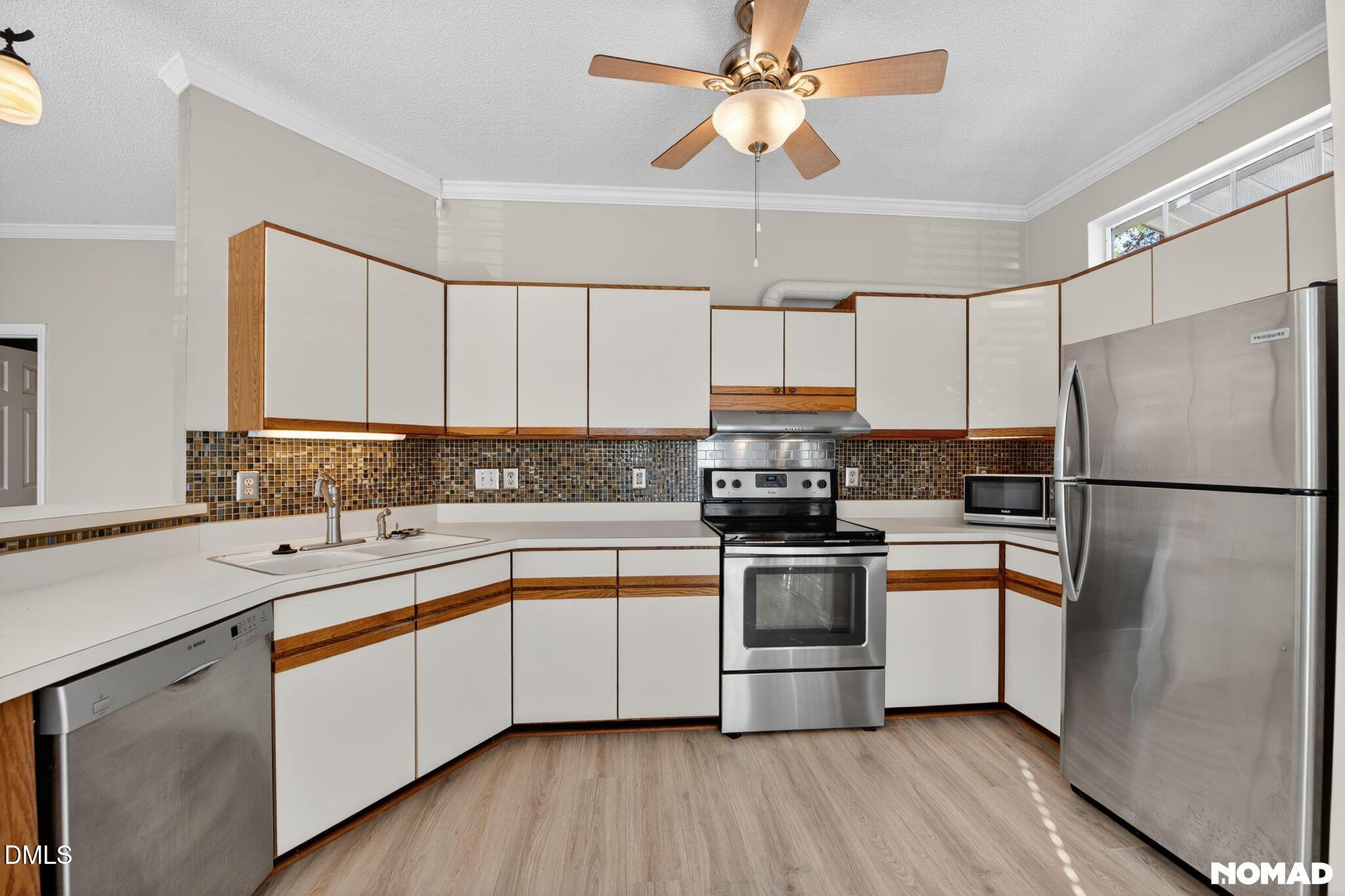 4456 Still Pines Drive Raleigh, NC 27613 - Photo 5 of 16 a kitchen with stainless steel appliances a refrigerator sink and cabinets