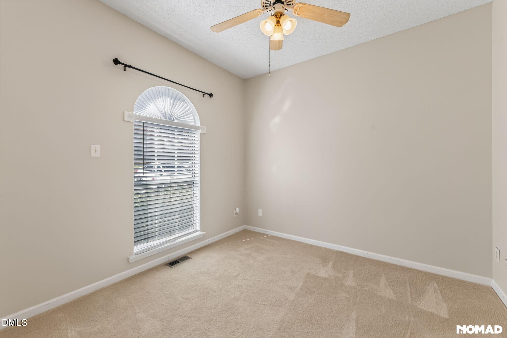 4456 Still Pines Drive Raleigh, NC 27613 - Photo 9 of 16 an empty room with windows and chandelier fan