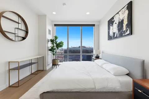 a bedroom with a large bed and a chandelier