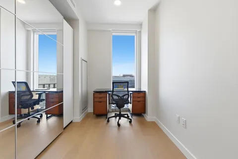 a view of a workspace with furniture and a window