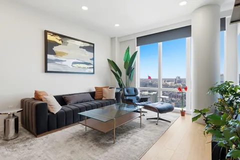a living room with furniture potted plant and a large window