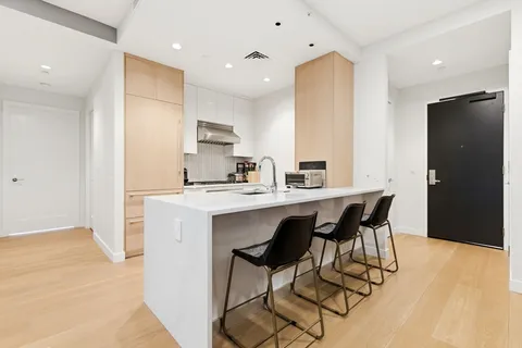 a kitchen with stainless steel appliances kitchen island granite countertop a sink and cabinets