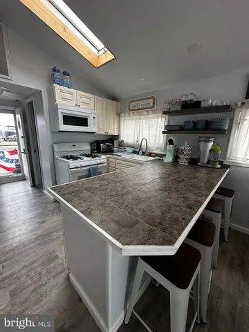 a kitchen with stainless steel appliances granite countertop a sink a stove and a microwave