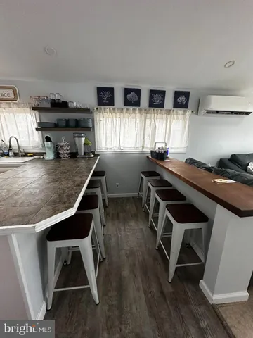 a kitchen with a sink a stove a window and white cabinets