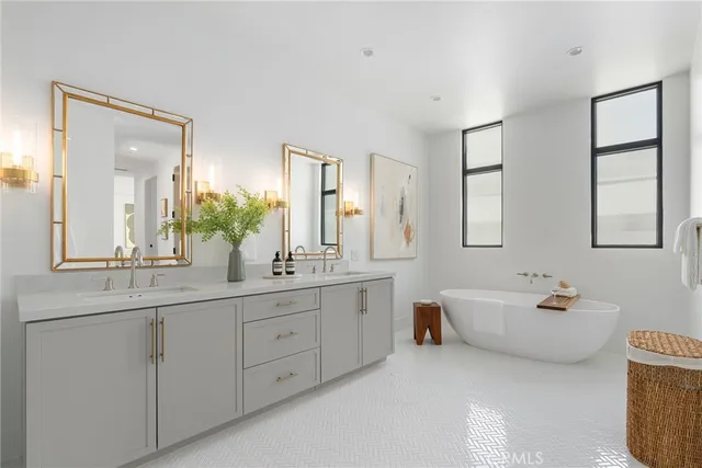 a spacious bathroom with double vanity a mirror a bathtub and window