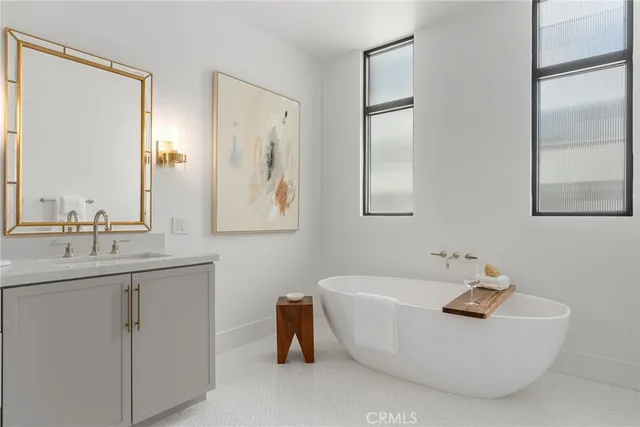 a bathroom with a tub sink and mirror