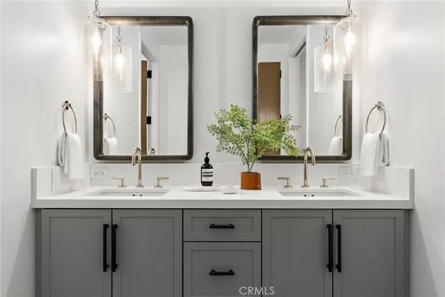 a bathroom with double sink and a mirror