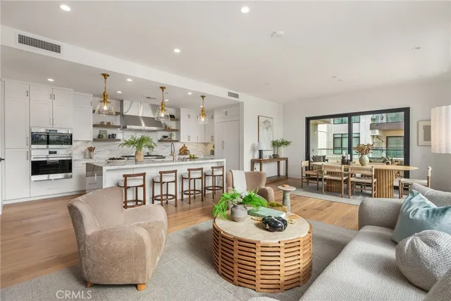 a living room with furniture kitchen view and a large window