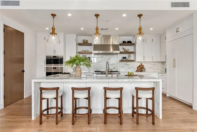 a kitchen with kitchen island granite countertop a table and chairs in it