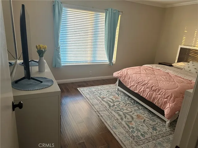 a bedroom with a bed and a dresser next to a window