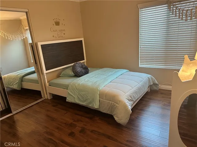 a bedroom with a bed and wooden floor