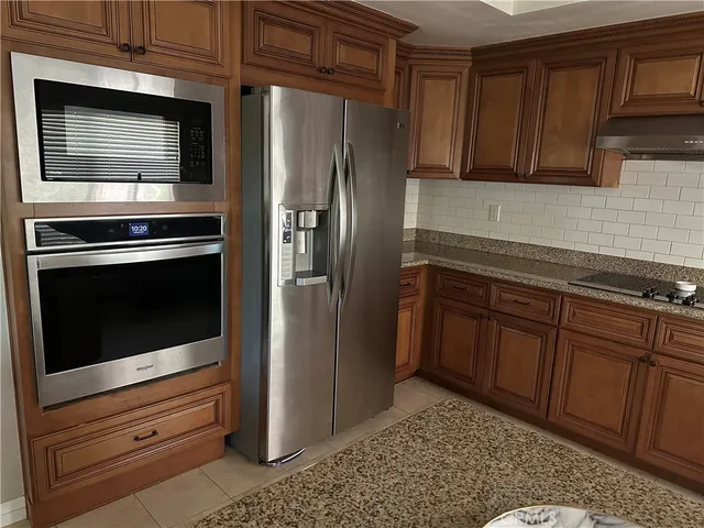 a kitchen with granite countertop wooden cabinets and stainless steel appliances