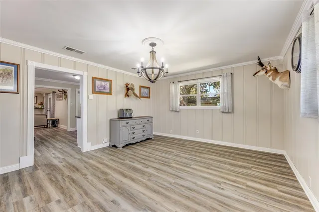 a view of a livingroom with wooden floor and chandelier