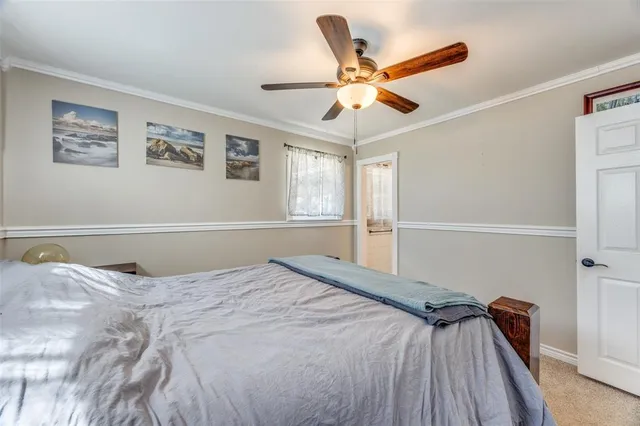 a bedroom with a large bed and a ceiling fan