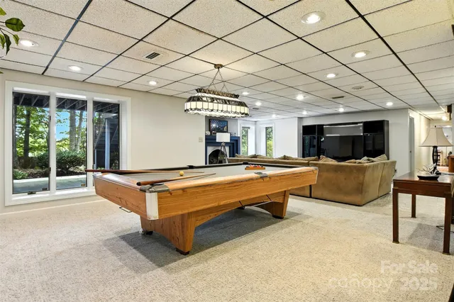 a living room with furniture pool table and a large window